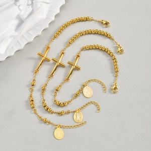 Vista detallada del set de pulseras de bolas doradas con medalla religiosa y cruz