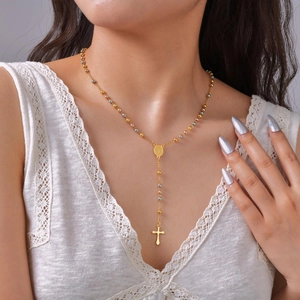 Women's gold and silver rosary necklace with religious medal and cross pendant on model