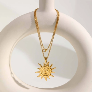 Minimalist stainless steel sun pendant necklace in gold finish on white display stand