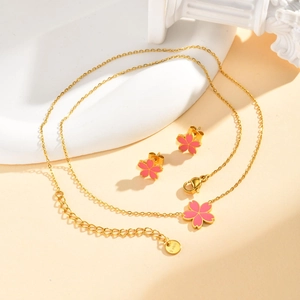 Détail de l'ensemble collier et boucles d'oreilles fleur de cerisier en émail rose doré