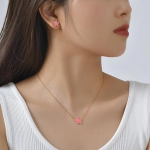 Détail d'une fille portant un ensemble de bijoux fleurs de cerisier dorés et émail rose