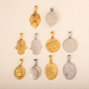Flat lay of multiple stainless steel lion and religious pendants in gold and silver