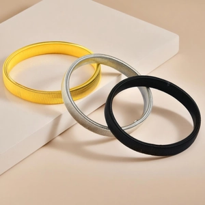 Set di tre bracciali elastici in metallo a molla nelle finiture oro, argento e nero