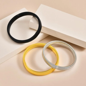 Tre bracciali a molla elastici in nero, oro e argento su pietre bianche decor
