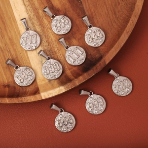 Macro shot of stainless steel lucky number pendants from 111 to 999 with hammered texture