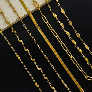 Golden stainless steel anklets in ball, snake, and paperclip chain styles on dark background