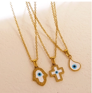 Detailed view of 24k gold plated evil eye necklaces with Hamsa hand and cross charms