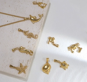 Macro detail van 24k vergulde hangers met zeedieren zoals dolfijnen en zeesterren