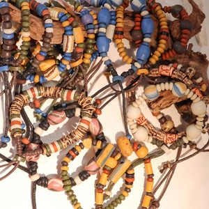 Bracciali etnici bohémien fatti a mano in ceramica di vari colori su rami di legno