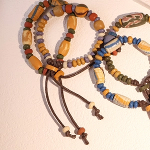 Dettaglio di bracciali etnici fatti a mano con perle in ceramica dai toni della terra