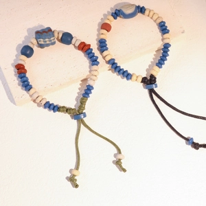 Dettaglio di braccialetti etnici in perline di ceramica con chiusura a cordoncino