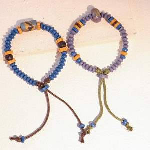 Macro di perle in ceramica colorate su bracciali intrecciati in stile etnico