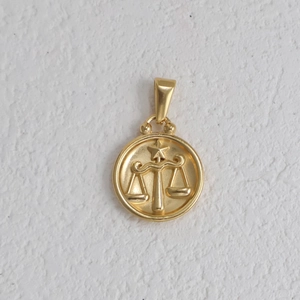 Macro d'un pendentif signe Balance en or avec détails de balance et étoile