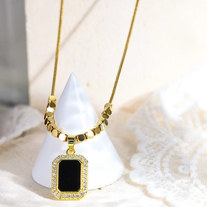 Dettaglio della collana vintage placcata oro 18K con ciondolo nero e bordo di zirconi