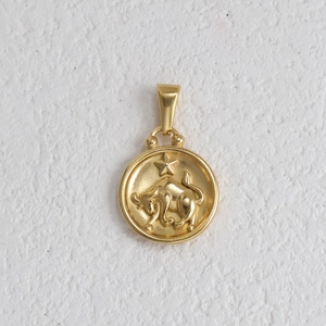 Vue macro d'un pendentif signe du Taureau doré avec finition mate et motif en relief