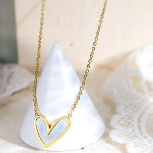 Dettaglio di una collana con ciondolo a cuore placcata oro 18K con madreperla bianca lucida