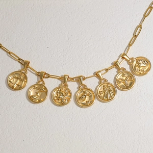 Collier chaîne trombone dorée avec plusieurs pendentifs gravés des 12 signes du zodiaque