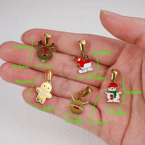 Détail de cinq pendentifs de Noël en émail tenus par la main pour bijoux DIY