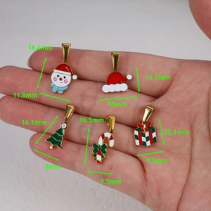 Détail de breloques de Noël DIY avec bonnet de Noël et sapin tenus pour l'échelle