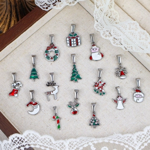 Détail de 15 pendentifs de Noël comprenant Père Noël et sapin dans un plateau en bois