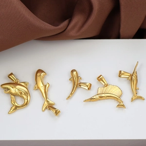 Detailed macro of gold plated stainless steel shark and dolphin animal pendants
