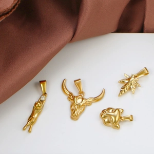 Detailed macro view of four gold-plated animal pendants with leaf and clear rhinestones