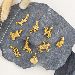 Golden 24k plated animal charms featuring lion, tiger, and fox on a stone surface