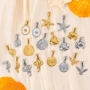 Golden and silver stainless steel ocean themed charms on elegant silk fabric background