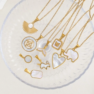 Détail de pendentifs plaqués or 24K avec incrustation de nacre dans un plat en verre