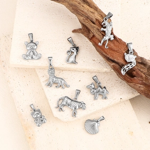 Macro shot of silver metal animal pendants on stone and wood for jewelry making