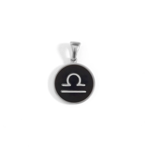 Macro detail of round black Libra zodiac pendant with polished silver frame and bail