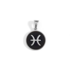 Macro shot of silver stainless steel Pisces zodiac pendant with black enamel disc