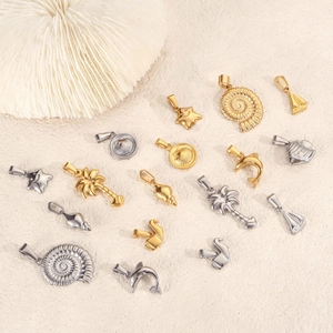Detail view of assorted gold and silver sea-themed pendants like dolphin and palm tree