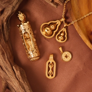 Golden titanium steel gourd and religious pendants on textured fabric background