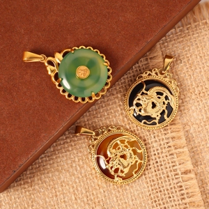Detalle de colgantes de dragón chino y collar de esmeralda con el símbolo Fu