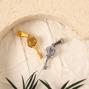 Exquisite 24k gold and silver key pendants with St. Benedict medal on white fabric