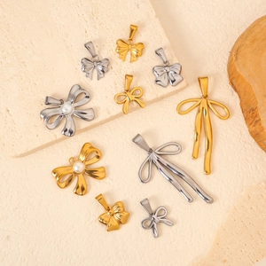 Vue macro détaillée de pendentifs nœuds en or et argent avec perles sur pierre texturée