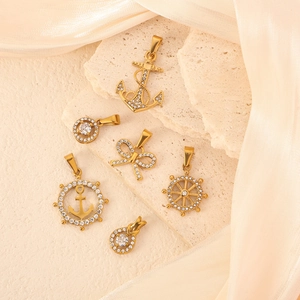 Gouden nautische hangers met anker en stuurwiel op elegante stenen ondergrond