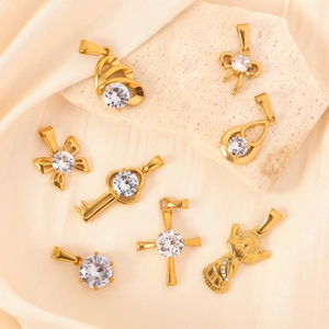 Set mit acht goldfarbenen Edelstahl-Anhängern mit Zirkon-Steinen auf Seide und Stein