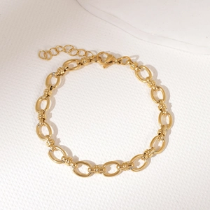 Bracelet gourmette en acier inoxydable doré avec fermoir mousqueton sur fond blanc