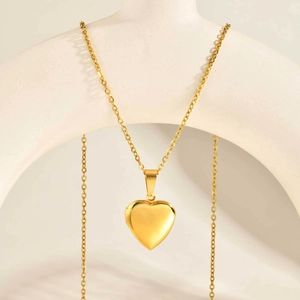 Detailed view of an openable gold heart locket pendant with a polished finish and chain