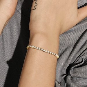 Detailaufnahme eines 18K vergoldeten Tennisarmbands mit funkelnden Zirkonsteinen