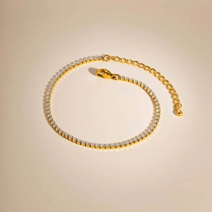 Detail eines goldenen Tennisarmbandes mit Zirkon-Steinen, Karabinerverschluss und Kette