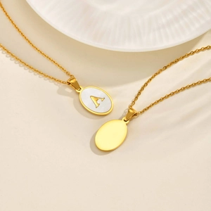 Gold oval white shell initial necklace with letter A on a delicate chain pendant