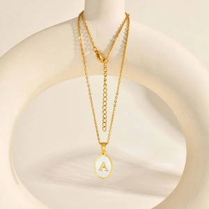 Gold stainless steel oval shell initial A necklace with adjustable chain on minimalist stand