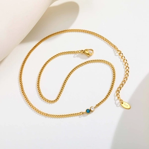 Dettaglio macro della catena placcata oro 18K con chiusura a moschettone e zircone