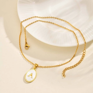 Detail of gold oval letter A pendant with white shell inlay and lobster clasp chain