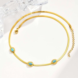 Dettaglio della collana a serpente dorata con tre pietre turchesi incastonate e chiusura a moschettone