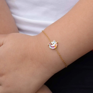 Detalle de una pulsera bañada en oro de 18K con un colgante de unicornio en esmalte