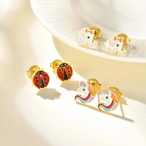 Detail view of unicorn elephant and ladybird enamel stud earrings set in gold finish